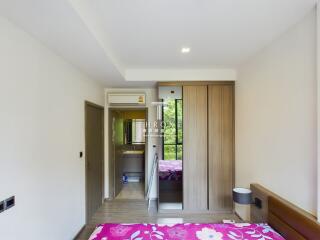 A spacious bedroom with floral bedding and large wardrobe