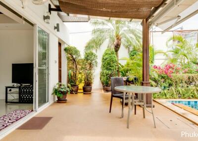 Covered patio with view of a pool and garden