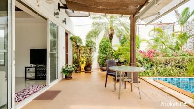 Covered patio with view of a pool and garden