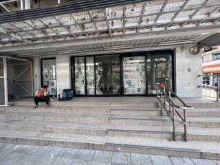 Front view of a commercial building with glass doors and metal railing