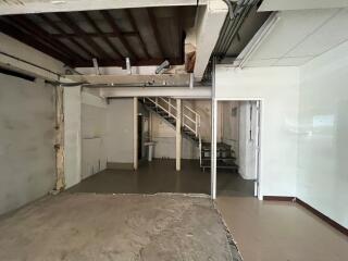 Unfinished interior space with exposed ceiling and partially constructed stairway