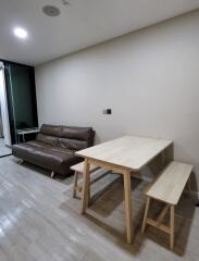 Minimalist living room with brown sofa and wooden dining table