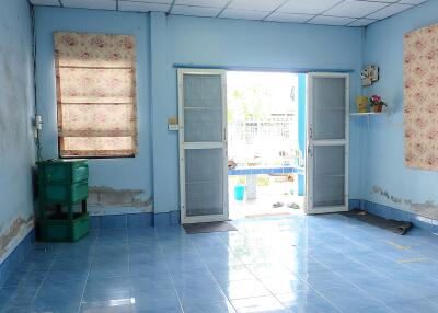 Living room with blue tiled floor, open French doors, and floral patterned curtains