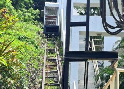 Hill-climbing railcar with track alongside a building