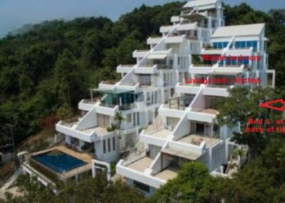 Multi-tiered white building with a pool and tiered balconies set into a hillside