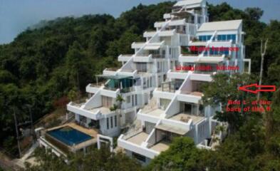 Multi-tiered white building with a pool and tiered balconies set into a hillside