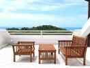 Terrace with wooden furniture and ocean view