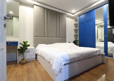 Modern bedroom with blue wardrobe and large bed