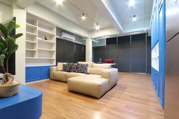 Spacious living room with modern decor, built-in shelves, and ample lighting