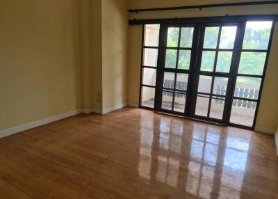 Spacious living room with large windows and wooden flooring