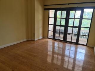 Spacious living room with large windows and wooden flooring