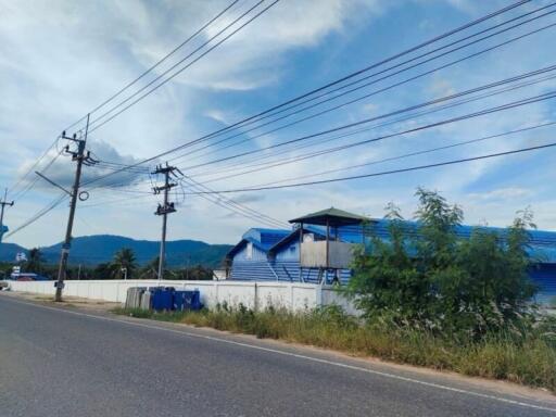 Exterior view of a blue-roofed building along a road