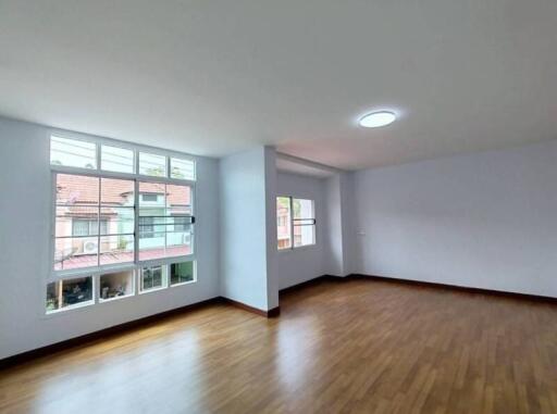 Spacious living room with wooden flooring and large windows