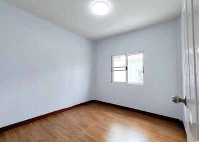 Empty bedroom with wooden floor and window