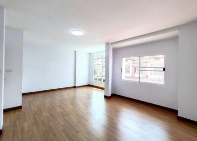 Spacious living room with hardwood floors and large windows