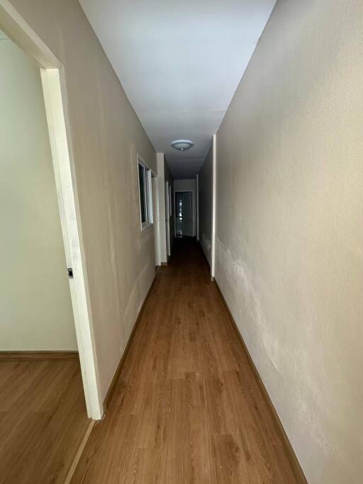 Interior hallway with wooden flooring and white walls