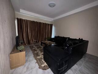 Living room with sectional sofa, rug, and curtains