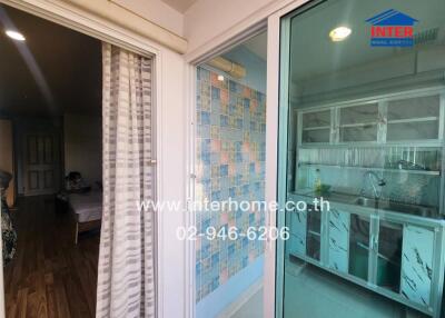 Sliding glass doors to room with mosaic tile wall and kitchen area