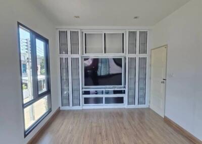 Spacious living room with large window and built-in entertainment unit