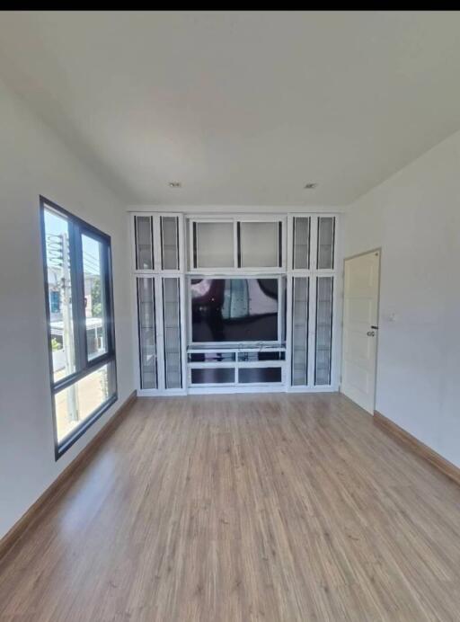 Spacious living room with large window and built-in entertainment unit