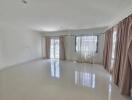 Spacious living room with large windows and tiled floor