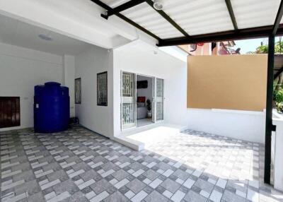 Covered outdoor area with tiled flooring and water storage tank