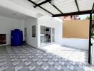 Covered outdoor area with tiled flooring and water storage tank