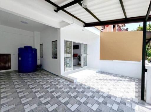Covered outdoor area with tiled flooring and water storage tank