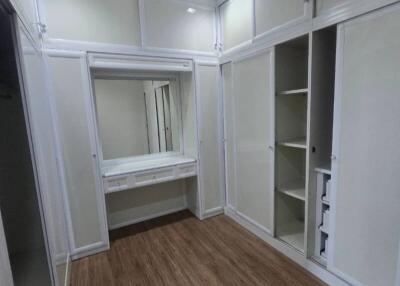 Spacious walk-in closet with built-in shelving and vanity