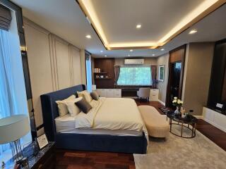 Modern bedroom with a bed, desk, and ambient lighting