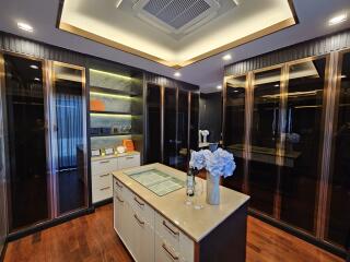 Luxury dressing room with island counter and glass cabinets