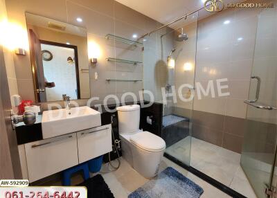 Modern bathroom with a large glass-enclosed shower, toilet, and sink