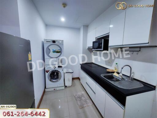 Modern kitchen with white cabinetry and laundry appliances