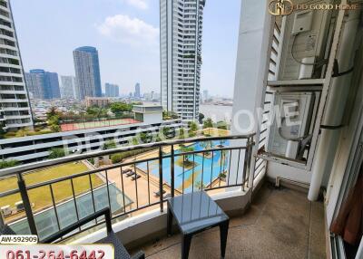 Balcony view of a high-rise building with a pool and cityscape in the background