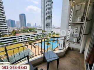 Balcony view of a high-rise building with a pool and cityscape in the background