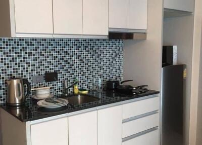 Modern kitchen with white cabinets and mosaic tile backsplash