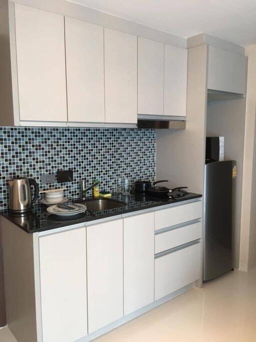 Modern kitchen with white cabinets and mosaic tile backsplash