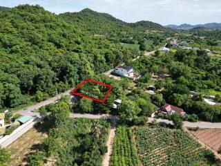 Aerial view of plot of land surrounded by greenery