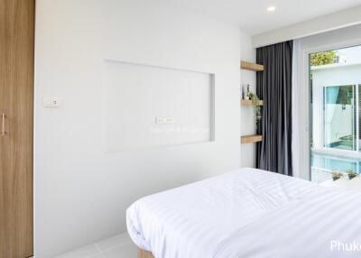 Modern bedroom with view of a swimming pool