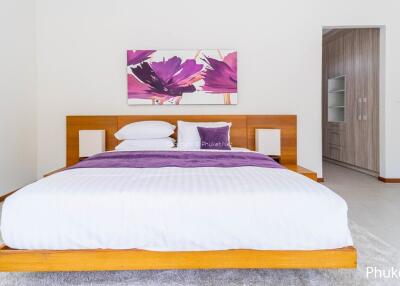 Modern bedroom with wooden bedframe and purple accents