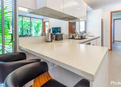 Modern kitchen with bar seating, appliances, and outdoor view