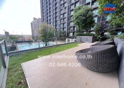 Condo outdoor seating area with city view and greenery