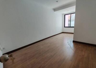 Empty bedroom with wooden floor and a window