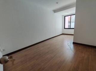 Empty bedroom with wooden floor and a window