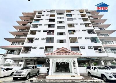 Front view of an apartment building with cars parked in front