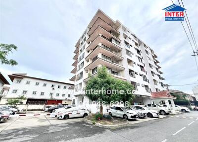 Exterior view of a multi-story residential building with parking area