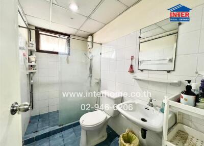 Bathroom with shower, toilet, sink, and mirror