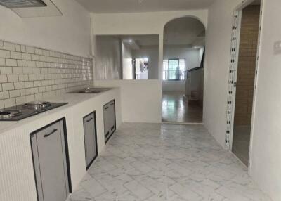 Modern kitchen area with tiled backsplash and marble floor