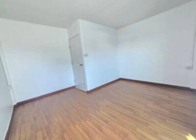 Empty bedroom with hardwood flooring and white walls