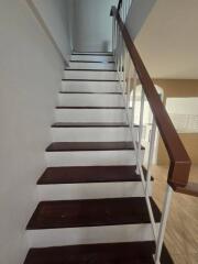 Staircase with wooden steps and white railing